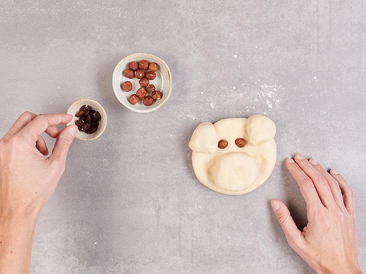 Teigschwein bekommt Augen aus Rosinen.