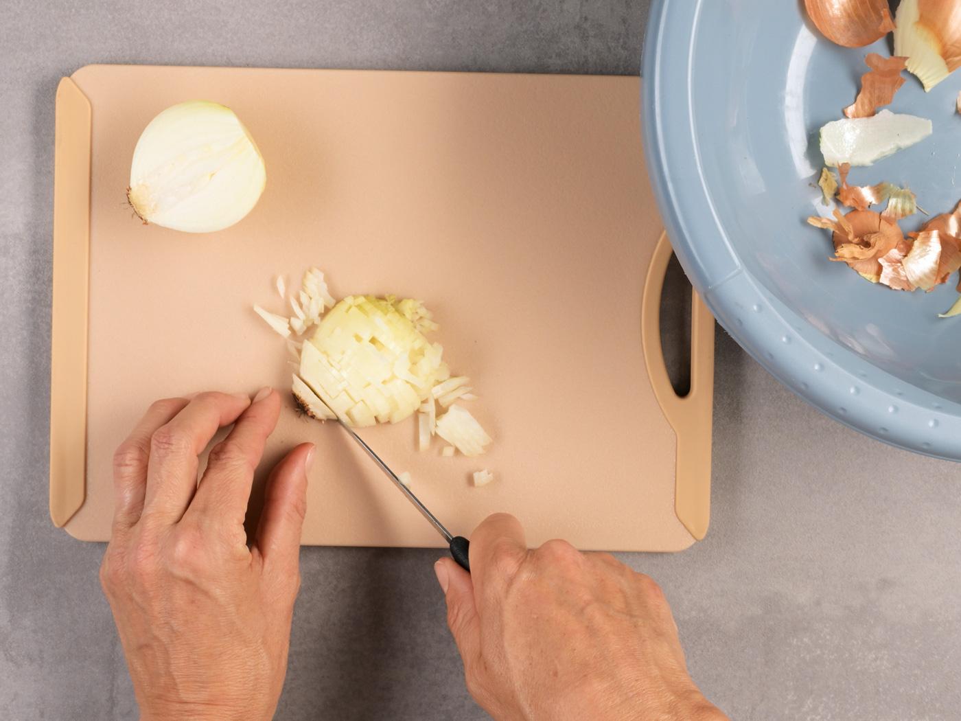 Zwiebelhälfte wird in gleichmässige Würfel geschnitten.